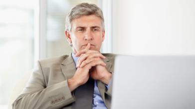 Middle aged business man at desk with laptop computer