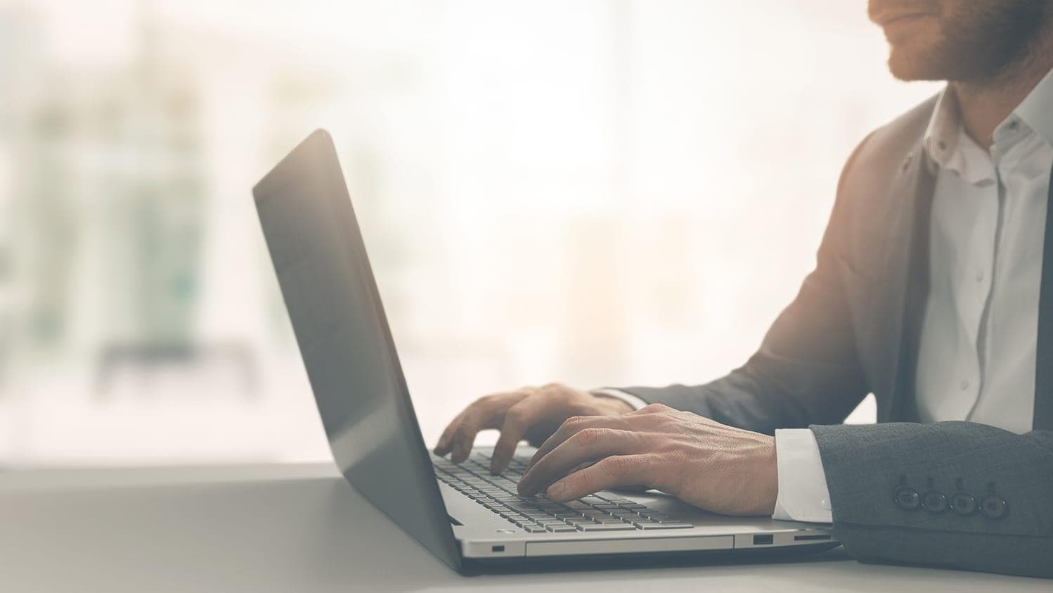 Young businessman using laptop in an open office setting