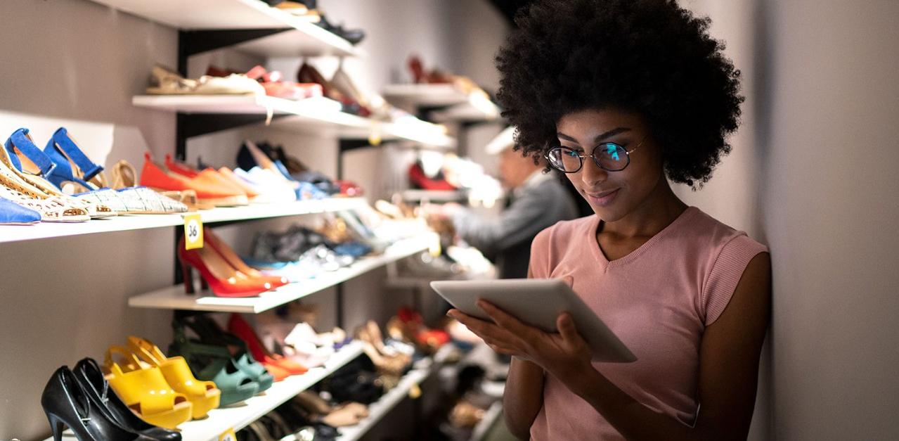 Woman looking at Tablet with Shoes CityScape the light trails on the modern buildings background