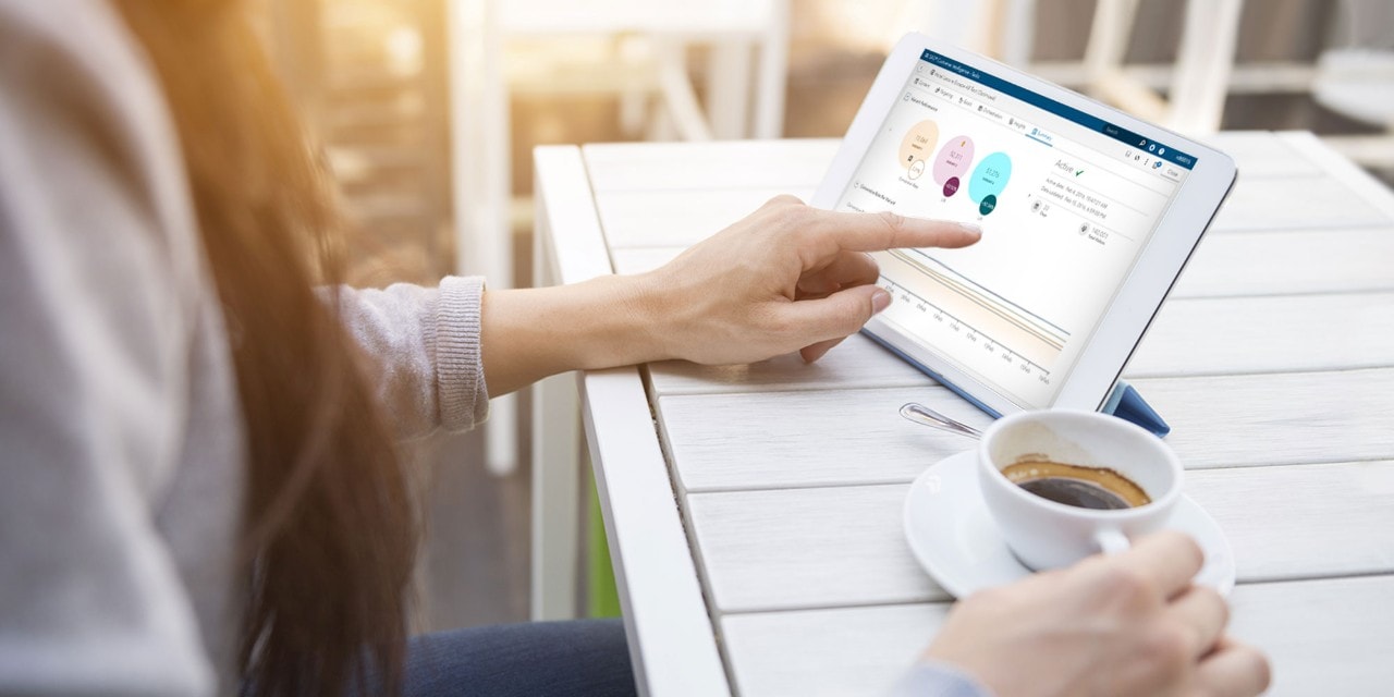 Woman using tablet on table with coffee