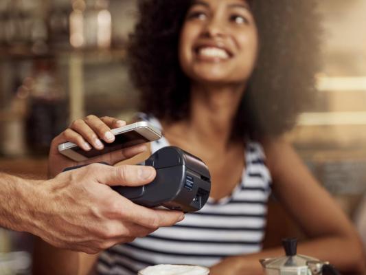 Woman paying bill by scanning her phone