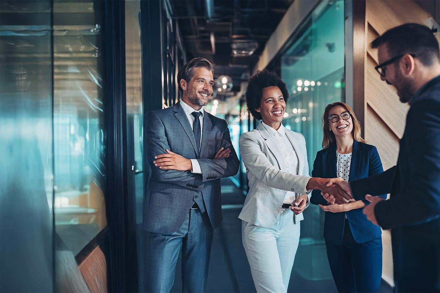 Small group of smiling business people shaking hands in the office