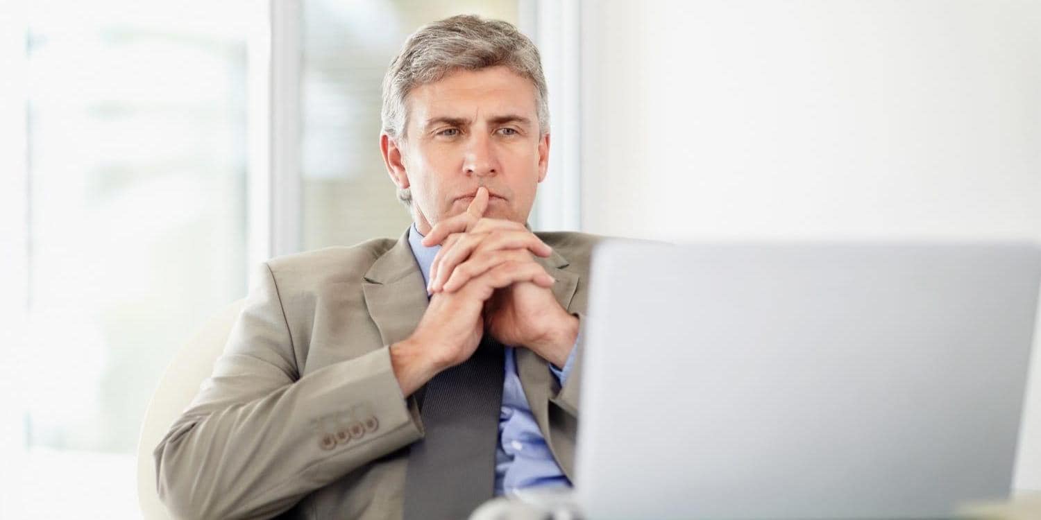 Middle aged business man at desk with laptop computer