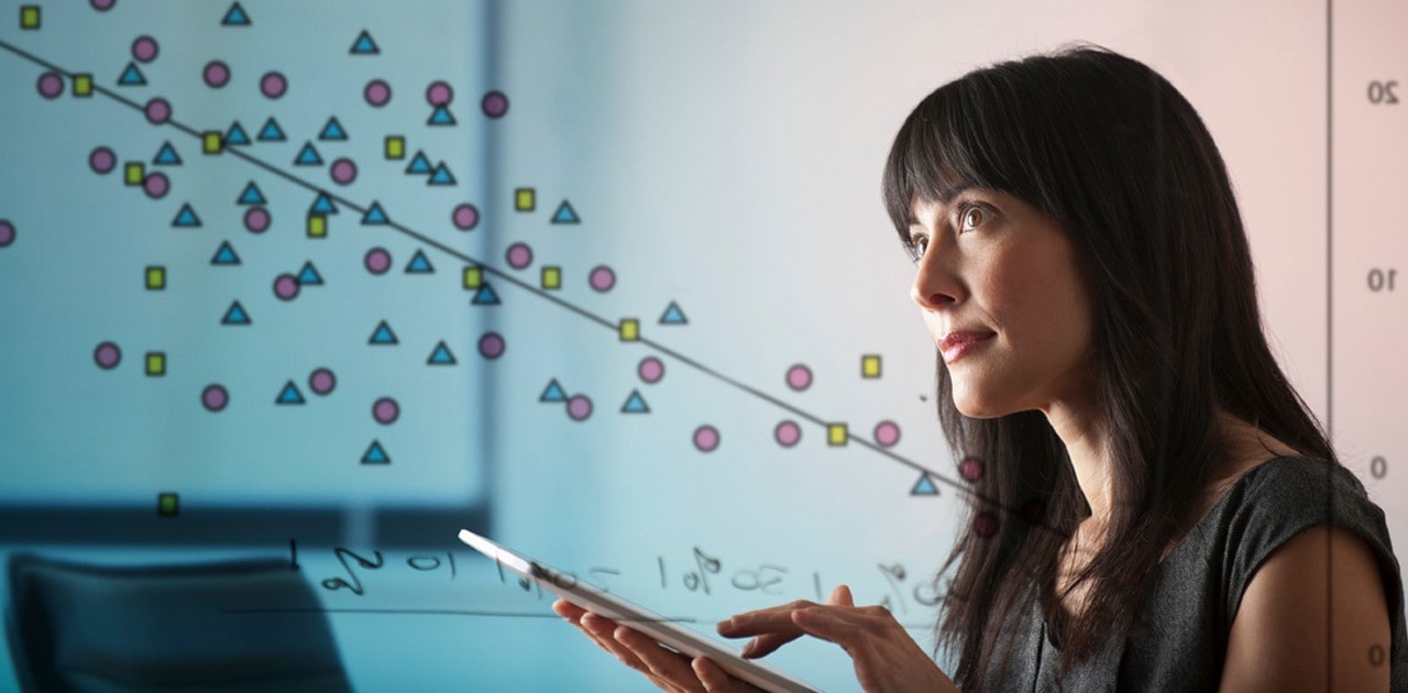 Woman working on tablet with diagram in background