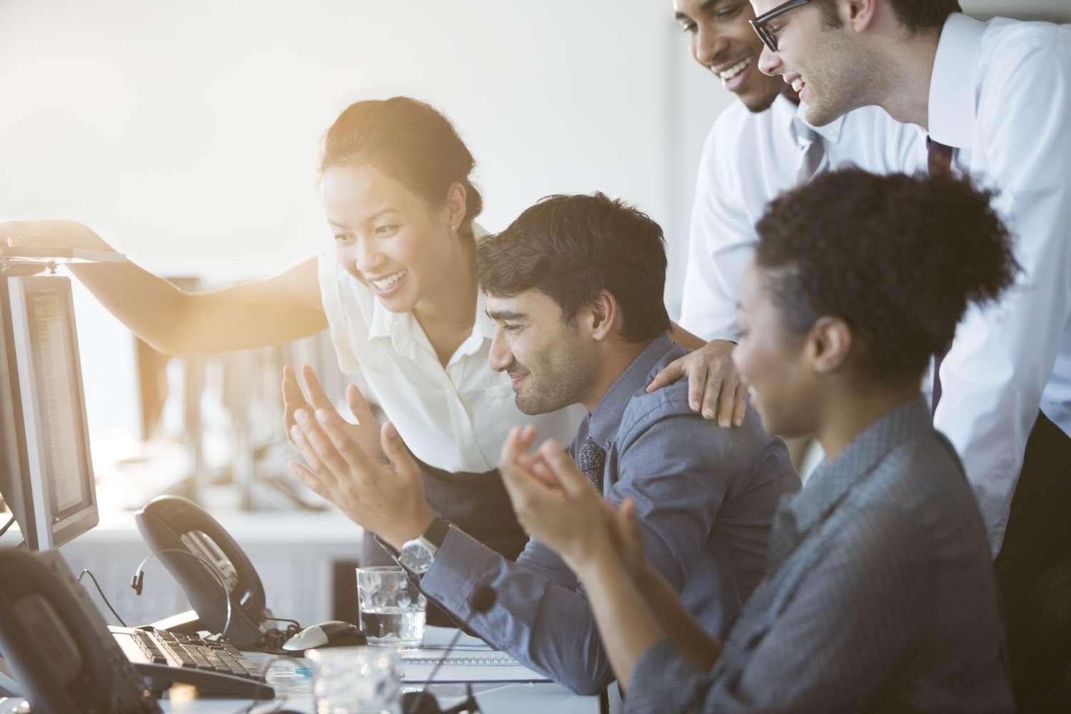 Business people cheering at computer in office 