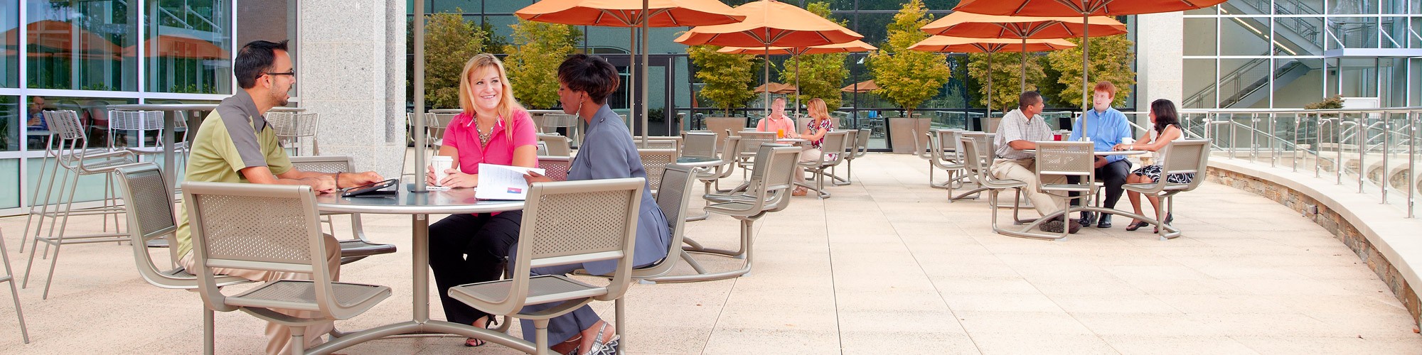 Employees sitting at tables of outdoor patio area at SAS headquarters in Cary NC