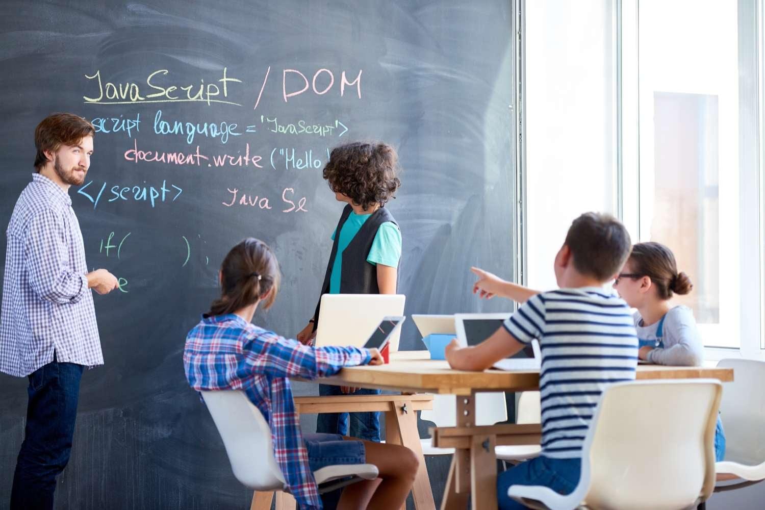Instructor teaches young students programming language