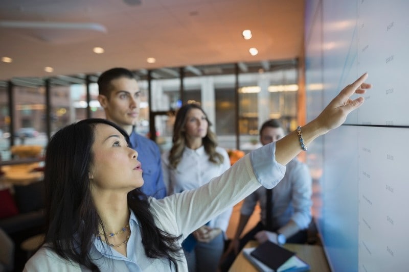 Business people pointing at projection screen Business people pointing at projection screen